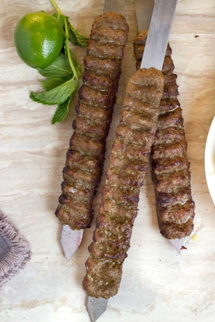   Esses espetos de carne e cordeiro grelhados se reúnem rapidamente, feitos com carne moída e cordeiro, cebola ralada e especiarias.  O zumajo de limão ou terra é o principal item para um verdadeiro sabor persa.  www.keviniscooking.com 